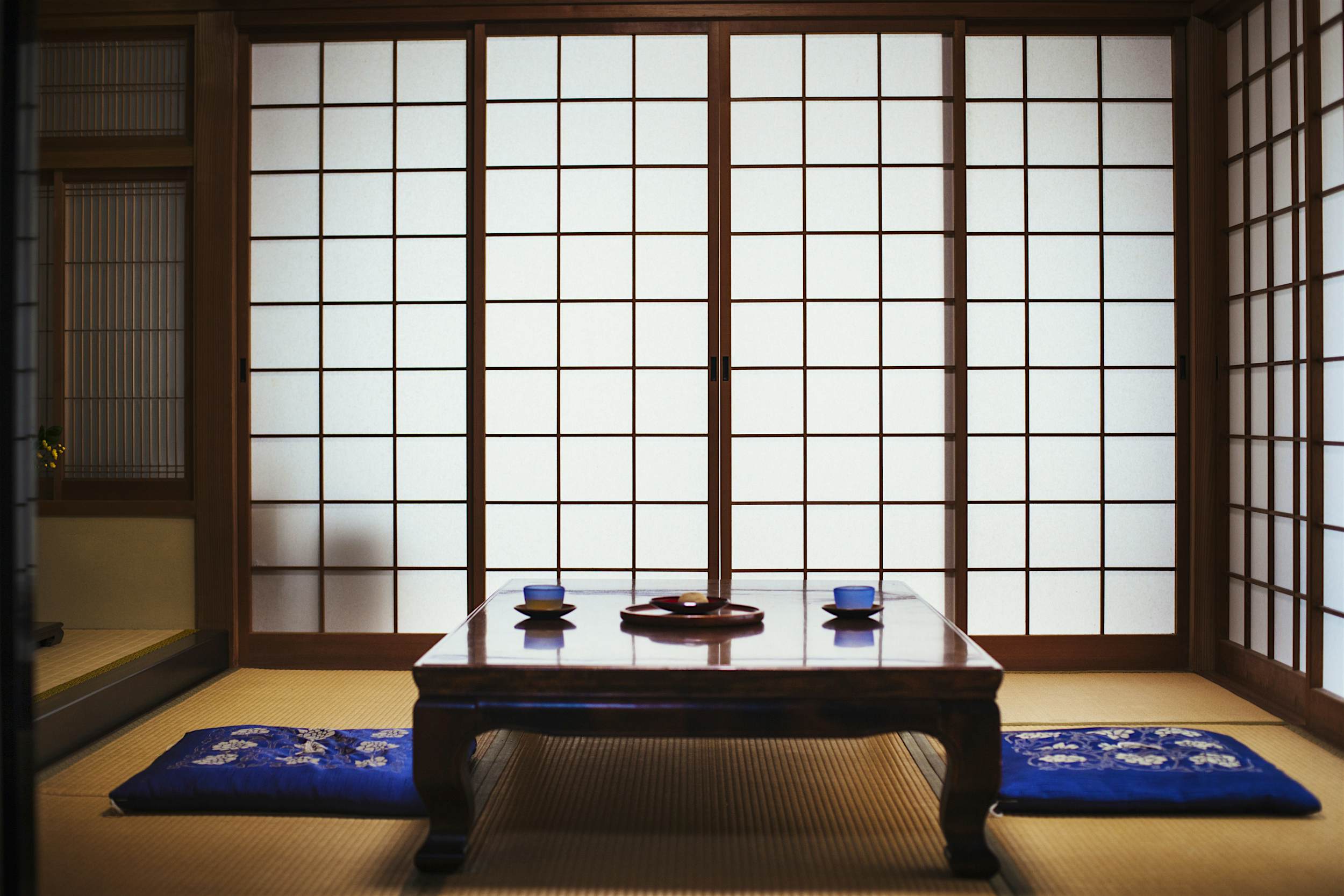 Travel News - Traditional Japanese interior with low table set with bowls of tea. Travellers will soon be able to stay at hundreds of temples across Japan.