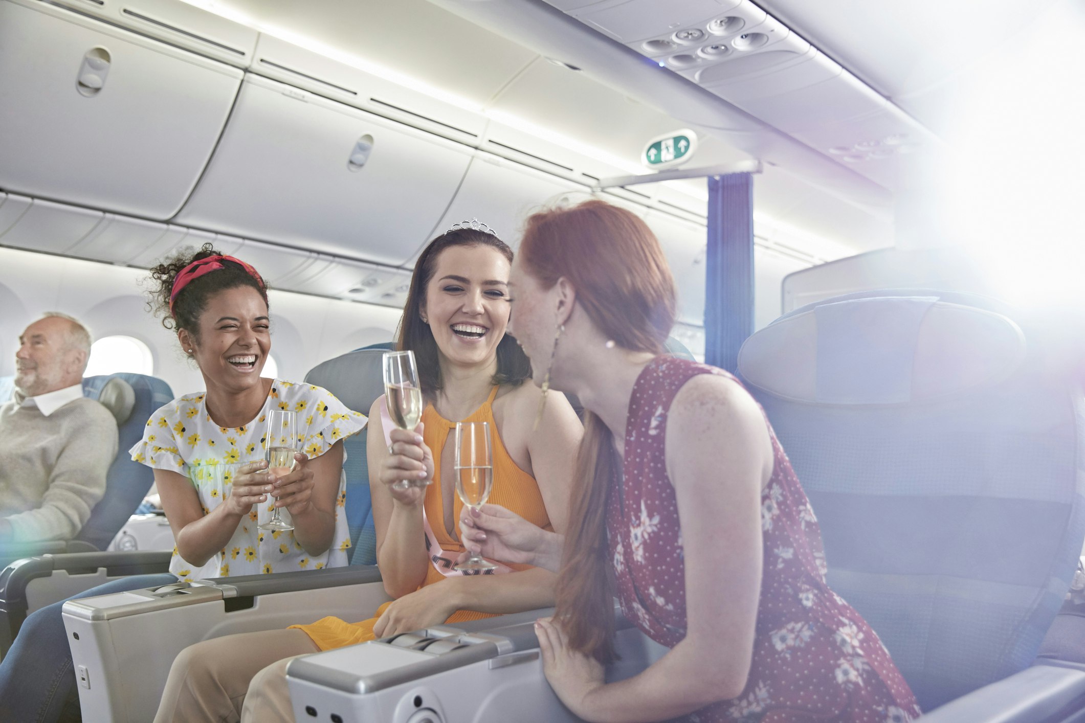 Three women drinking wine on a plane