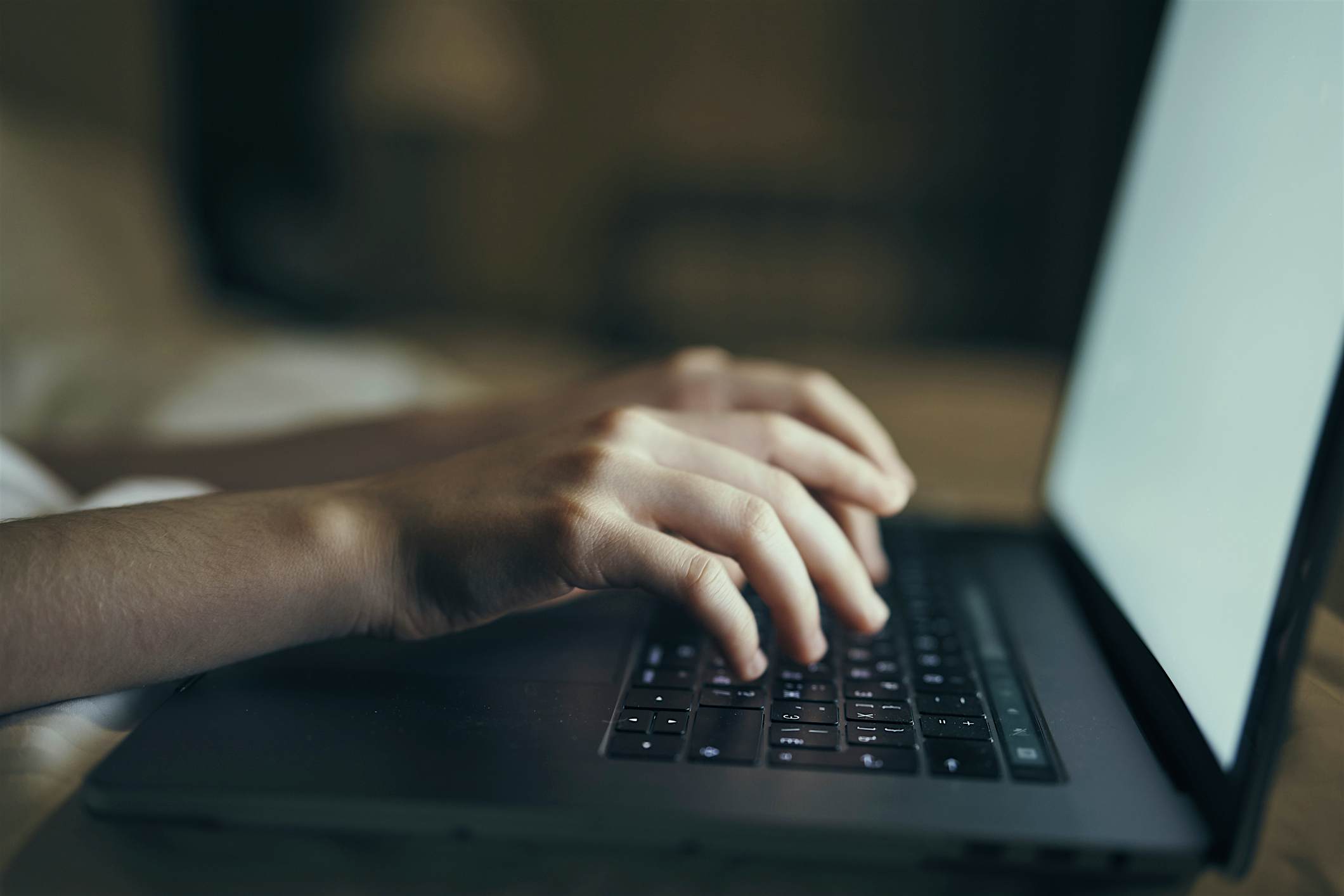 Travel News - Hands of Caucasian woman typing on laptop in bed Travel News - Hands of Caucasian woman typing on laptop in bed
