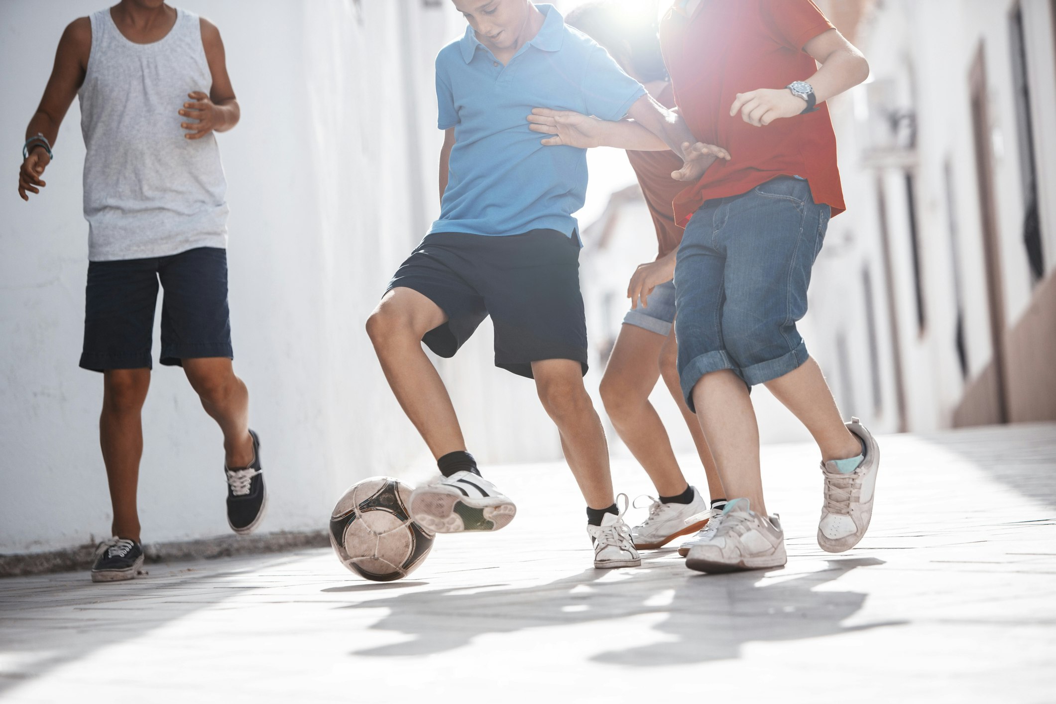 Children playing with soccer ball in alley