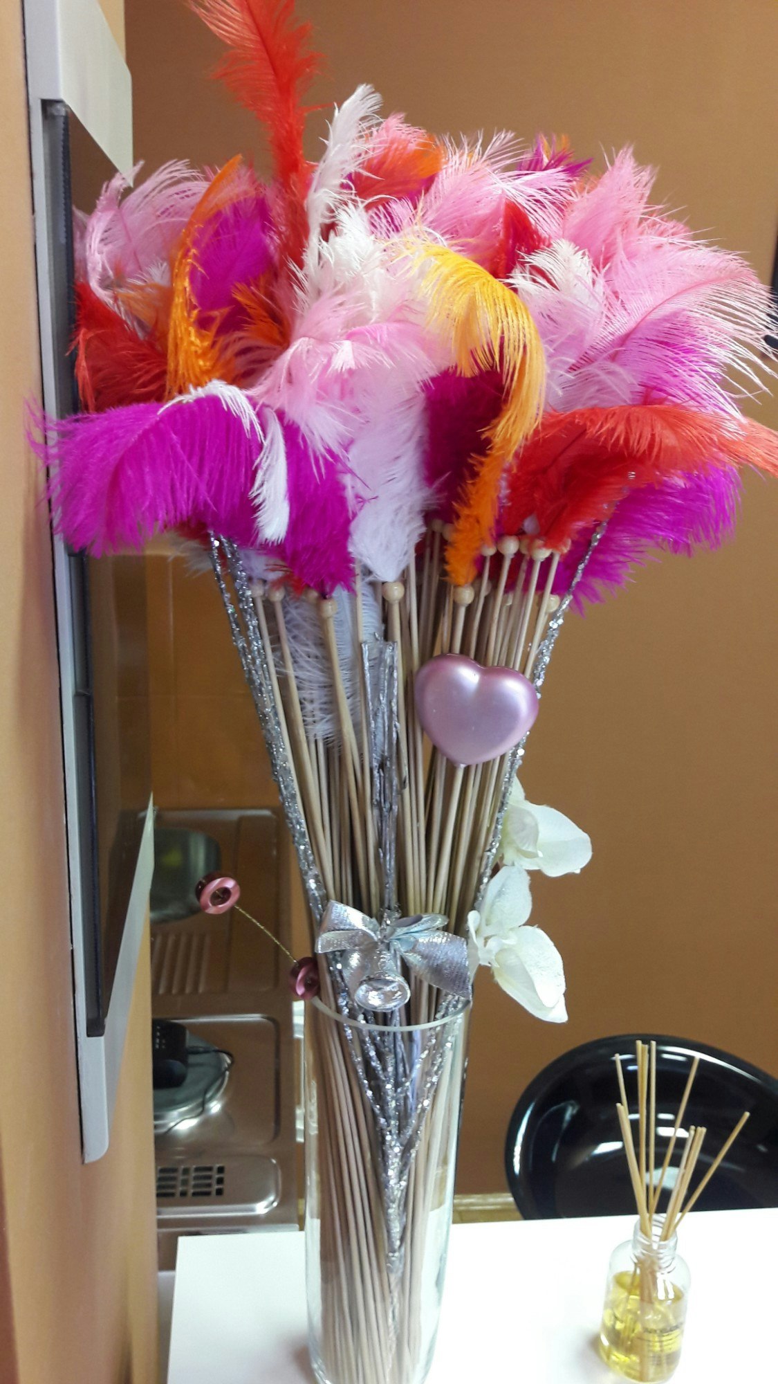 A bunch of colourful feathers in a vase.