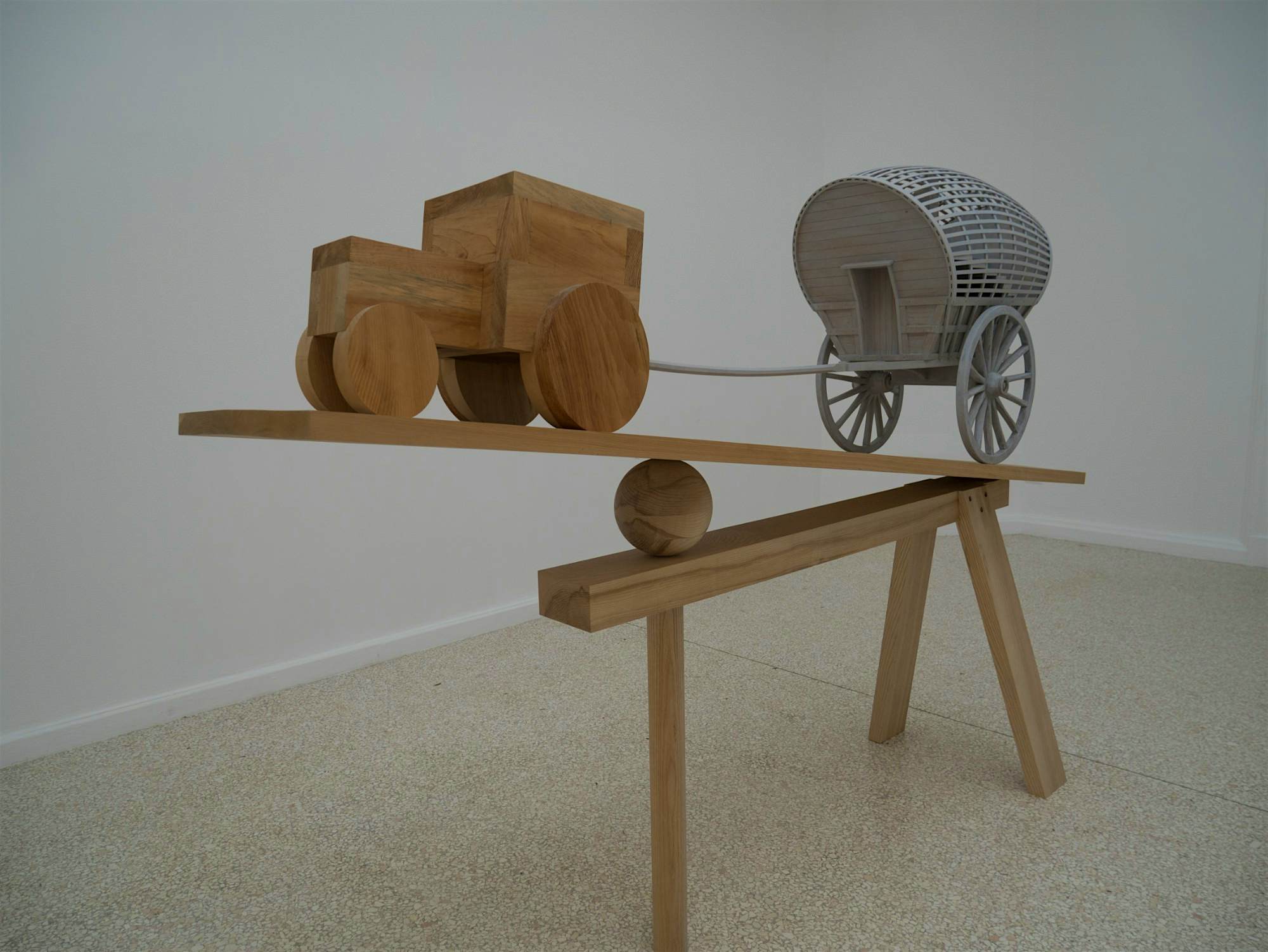 Travel News - Veniceart An installation of a wooden tractor pulling a cart.