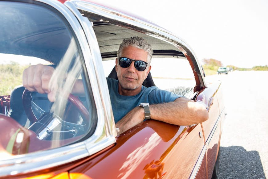 Anthony Bourdain driving a vintage car in Havana.