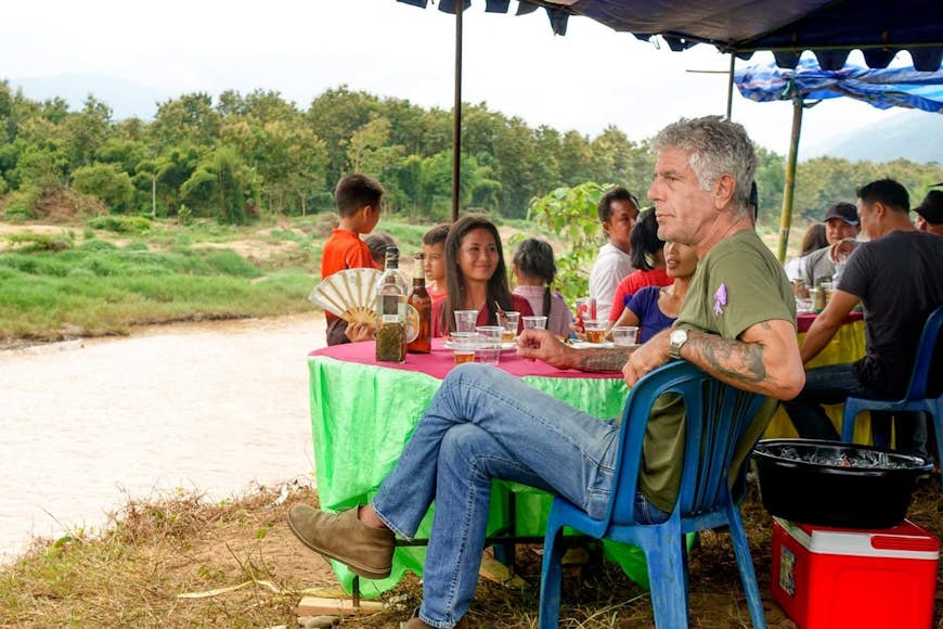Anthony Bourdain sitting on the banks of a river in Korea.