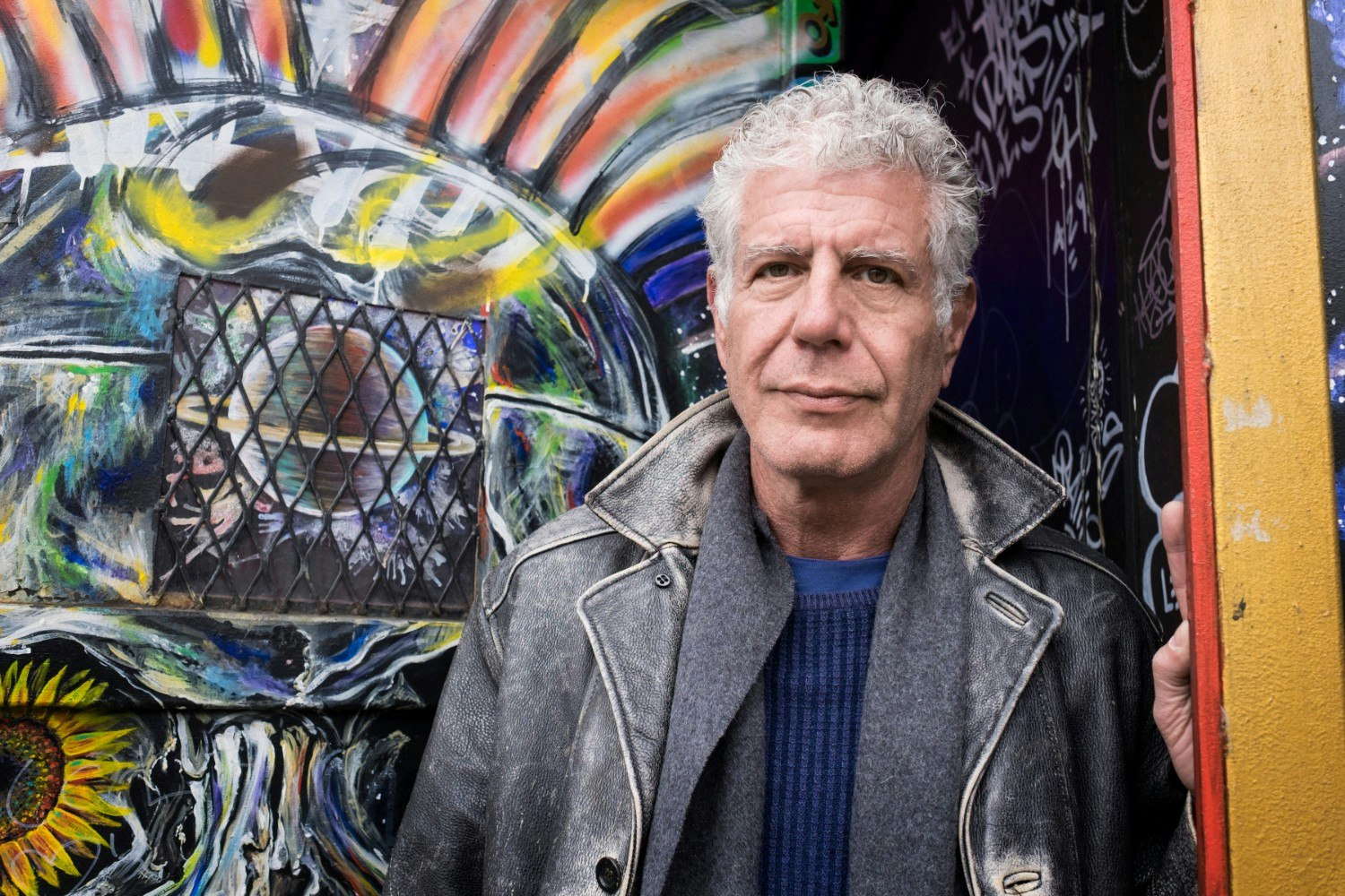 Anthony Bourdain at a decorated wall in the Lower East Side of New York CIty
