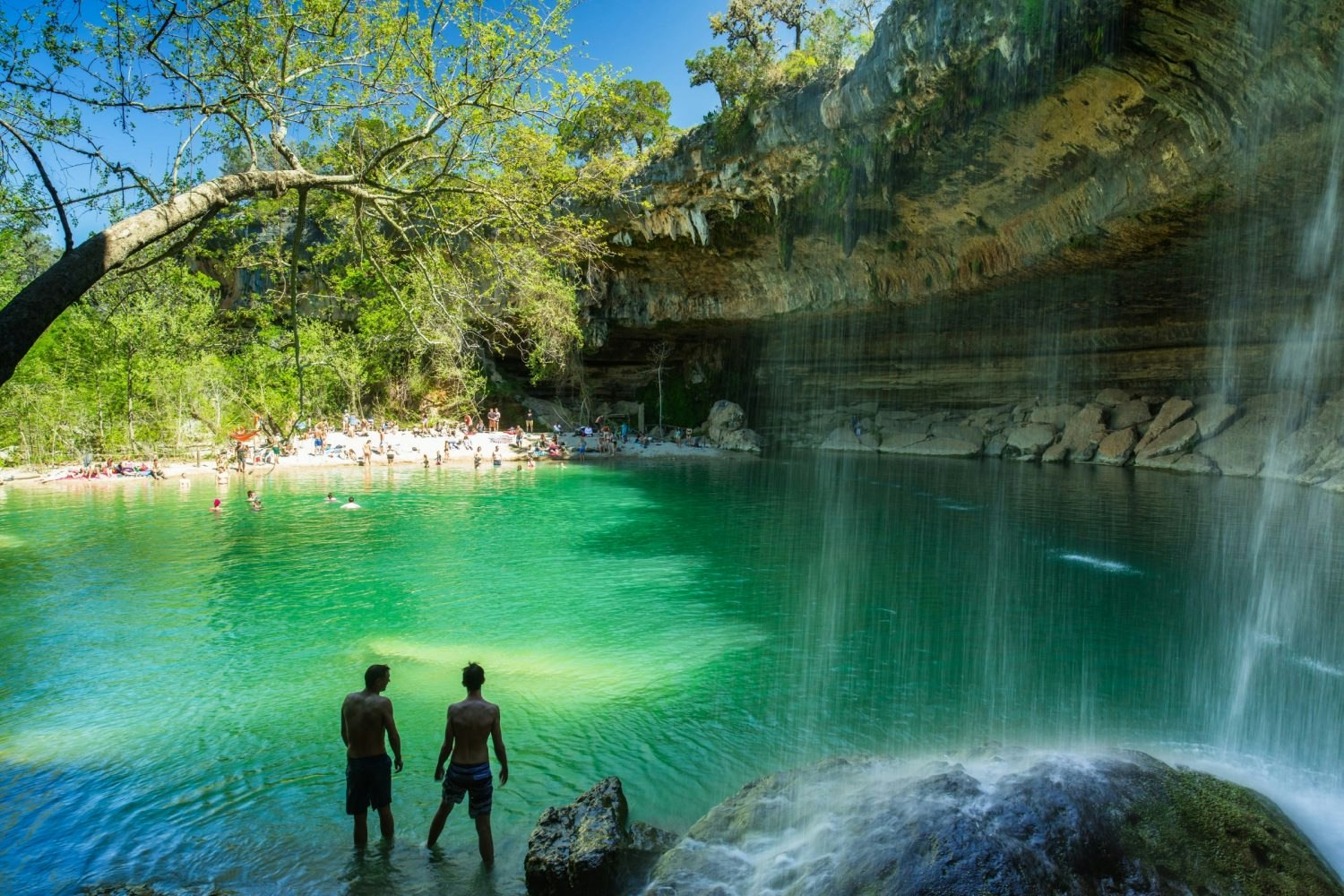 People swimming at the natural Hamilton Pool in rural Travis County, Texas. 