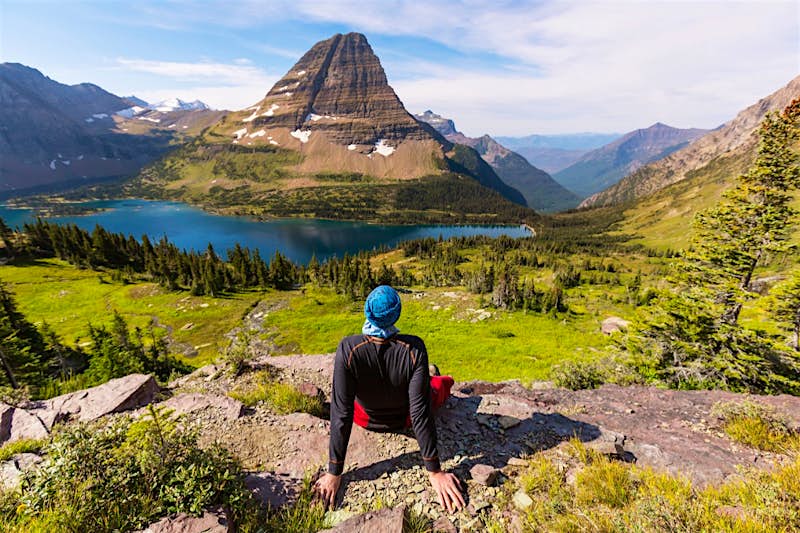 Travel News - Glacier National Park hiker Hiker takes a break on the rocks in Glacier National Park.
