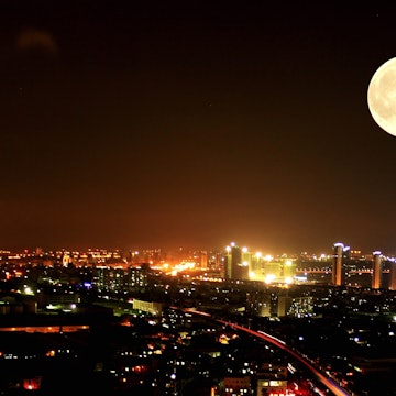 A supermoon over a city at night.