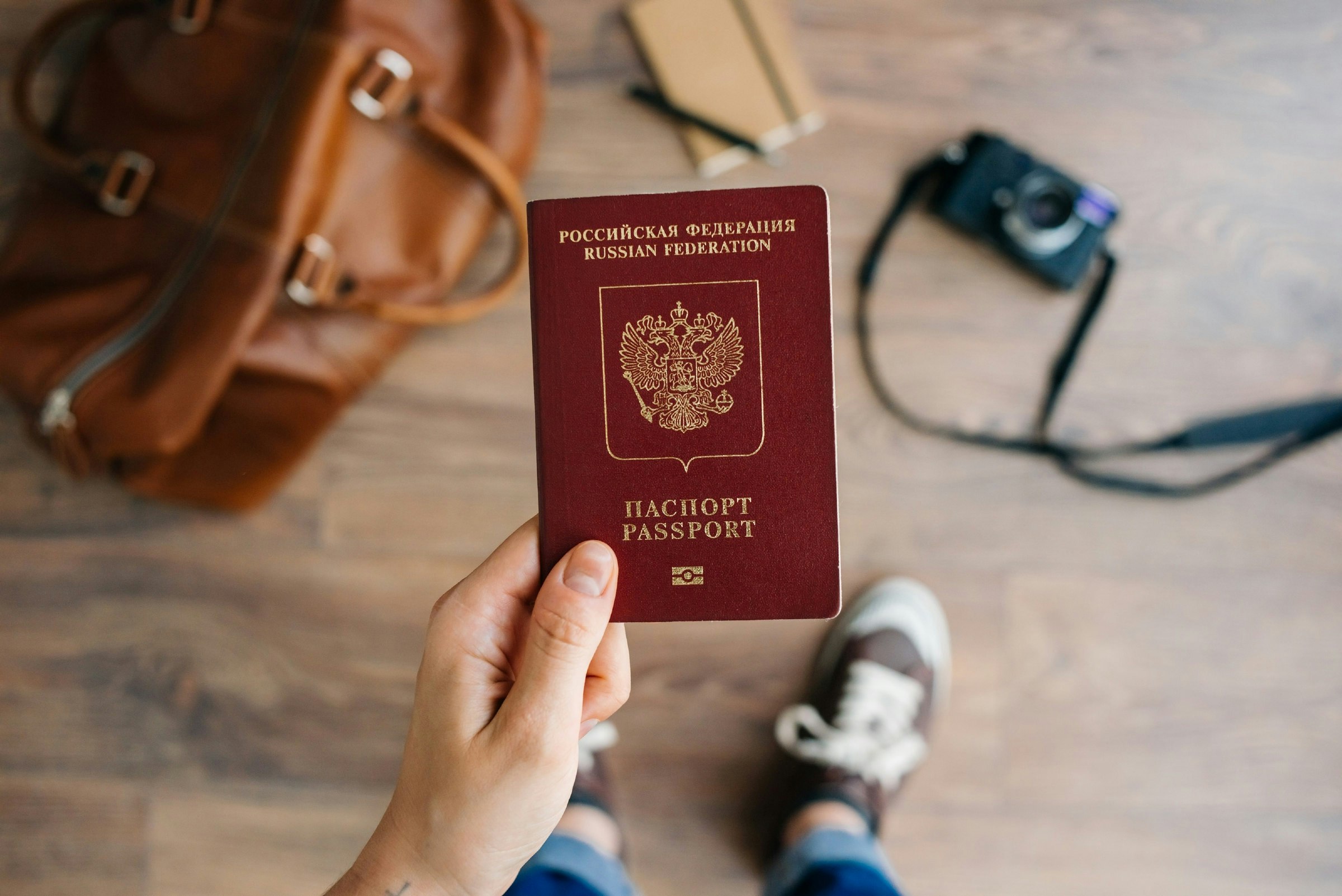 A hand holding a red Russian passport