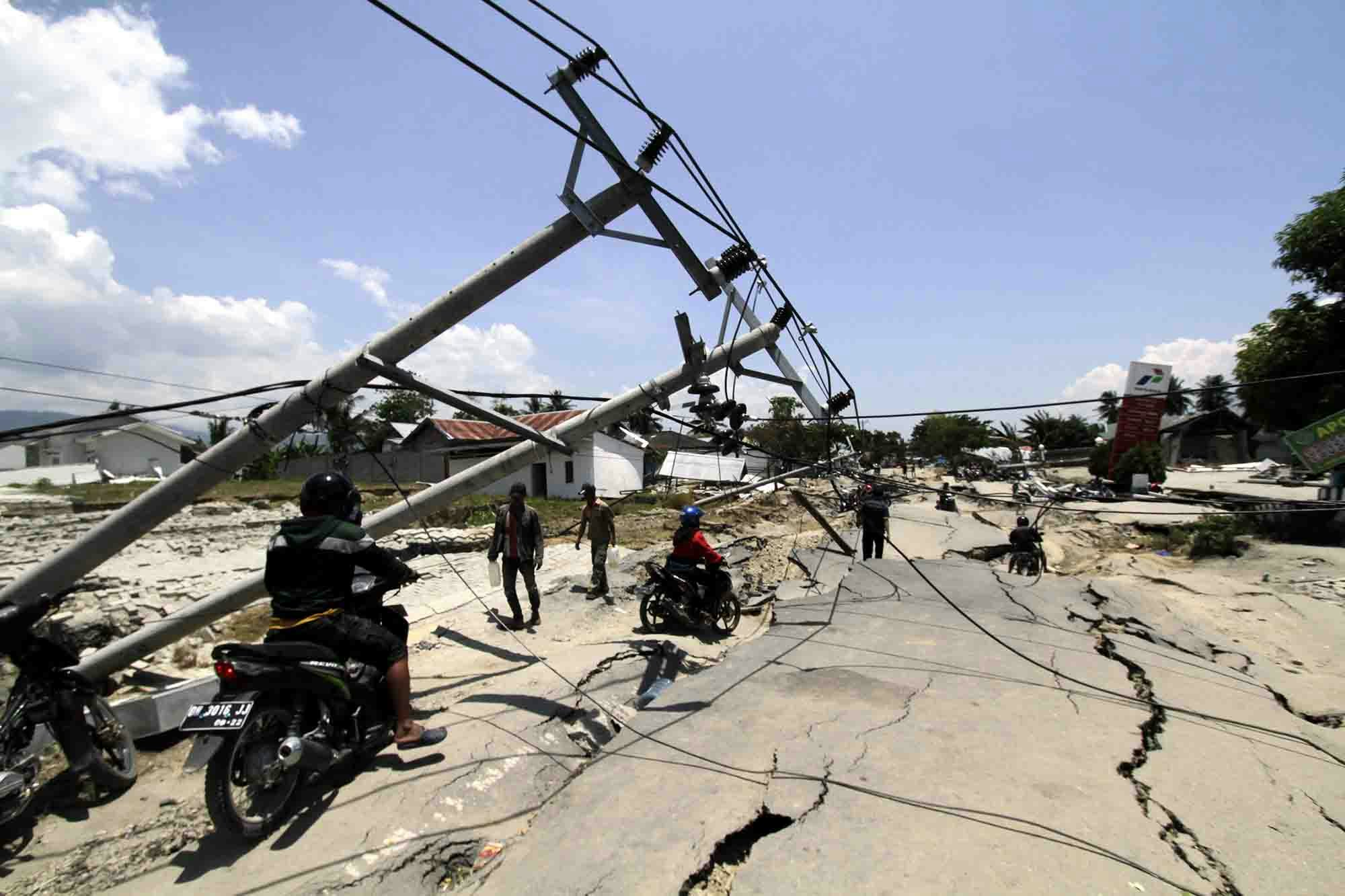 Palu residents help to clear a road following an earthquake