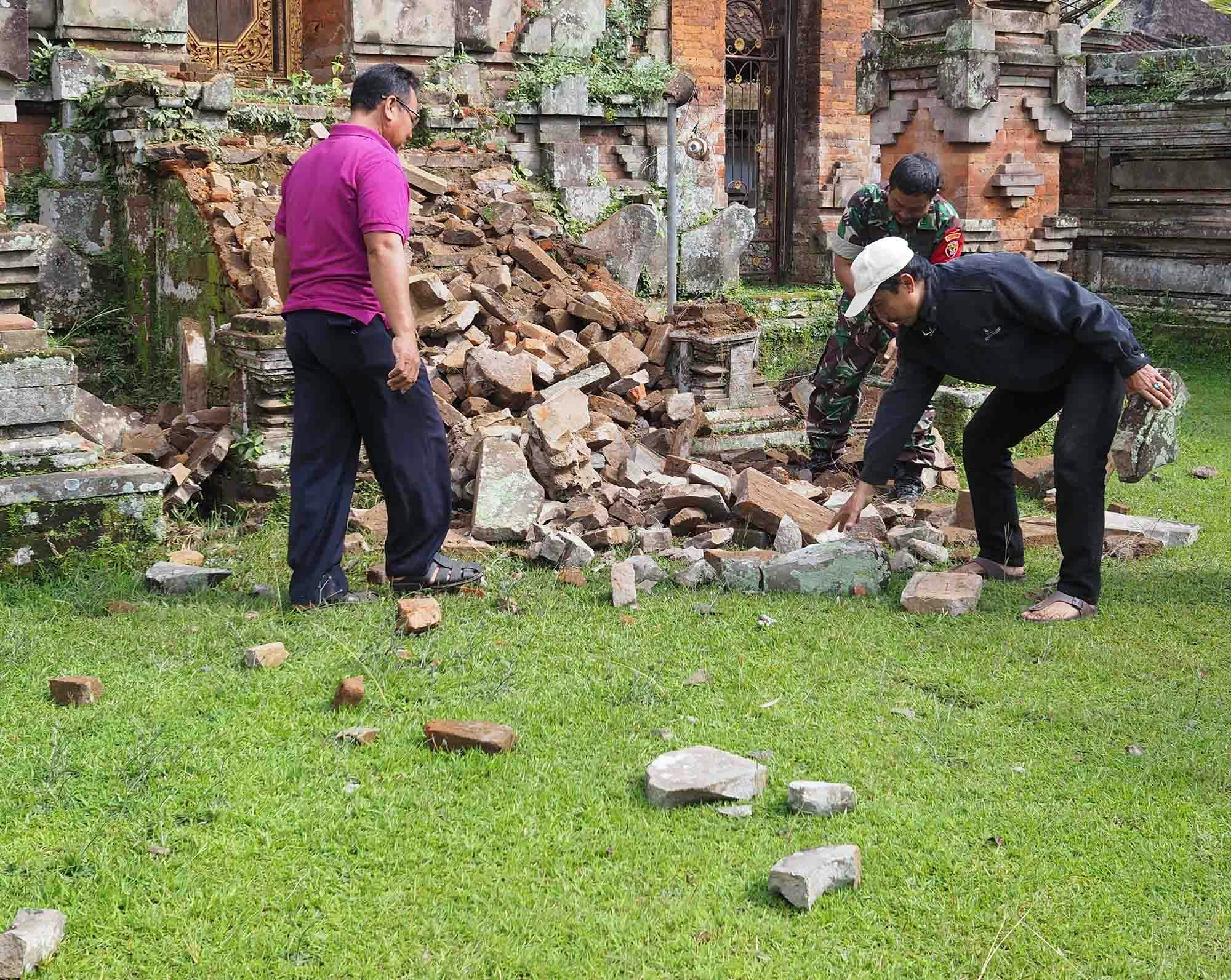 Bali officials inspecting a damaged temple following an earthquake in 2018