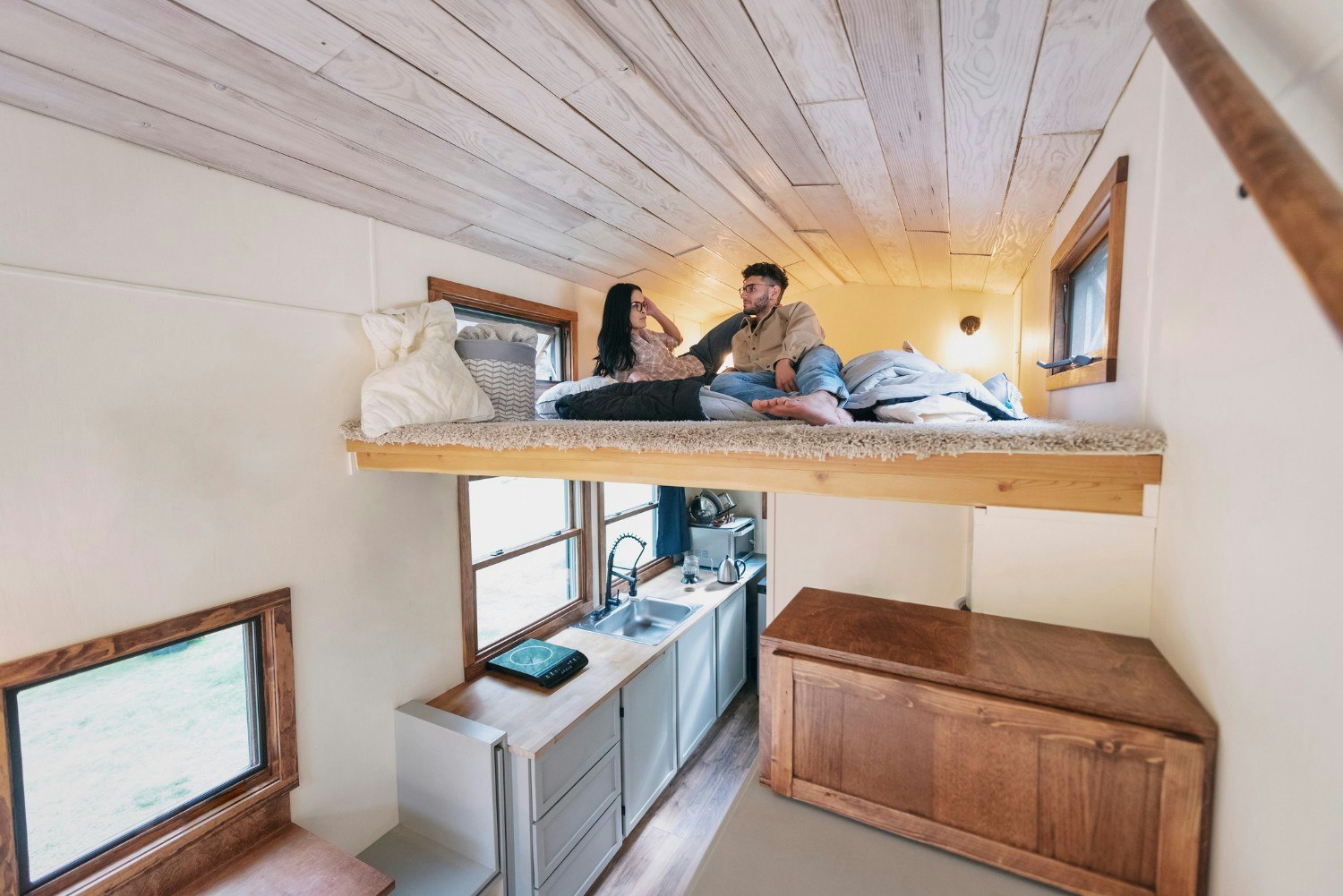 A young couple in the bedroom loft of tiny house 