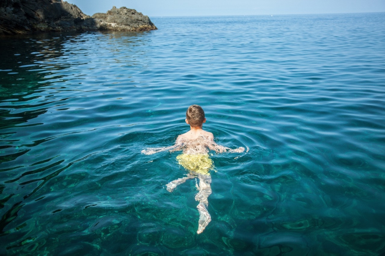 A boy swimming in clear waters.