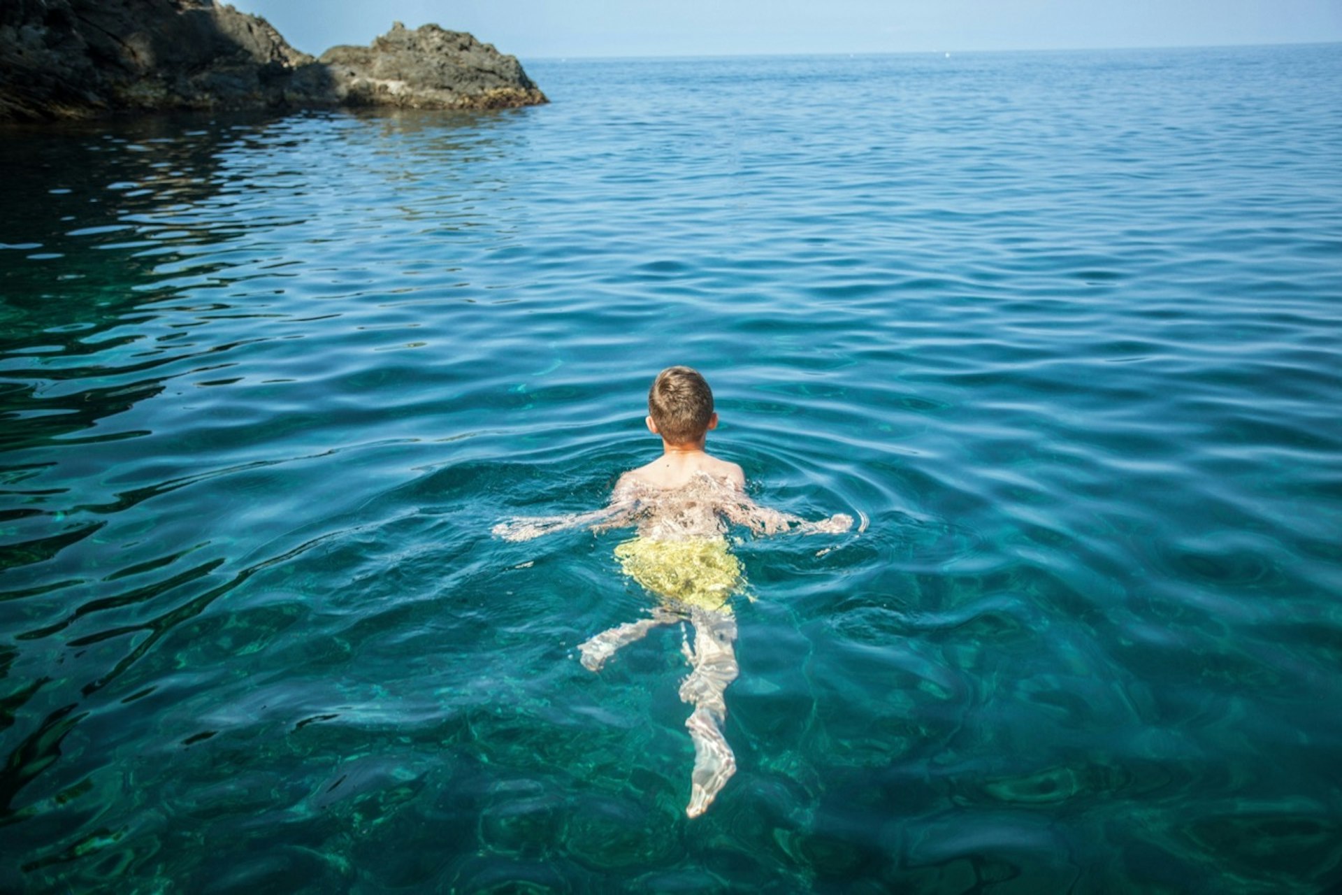 A boy swimming in clear waters.