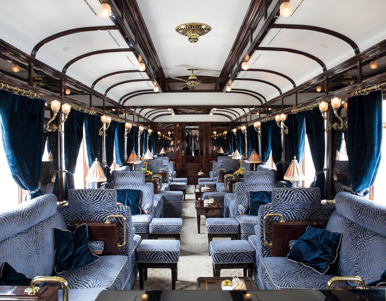 An interior view of the Venice Simplon-Orient-Express train; the luxurious lounge carriage is decorated with sumptuous deep blue soft furnishings.